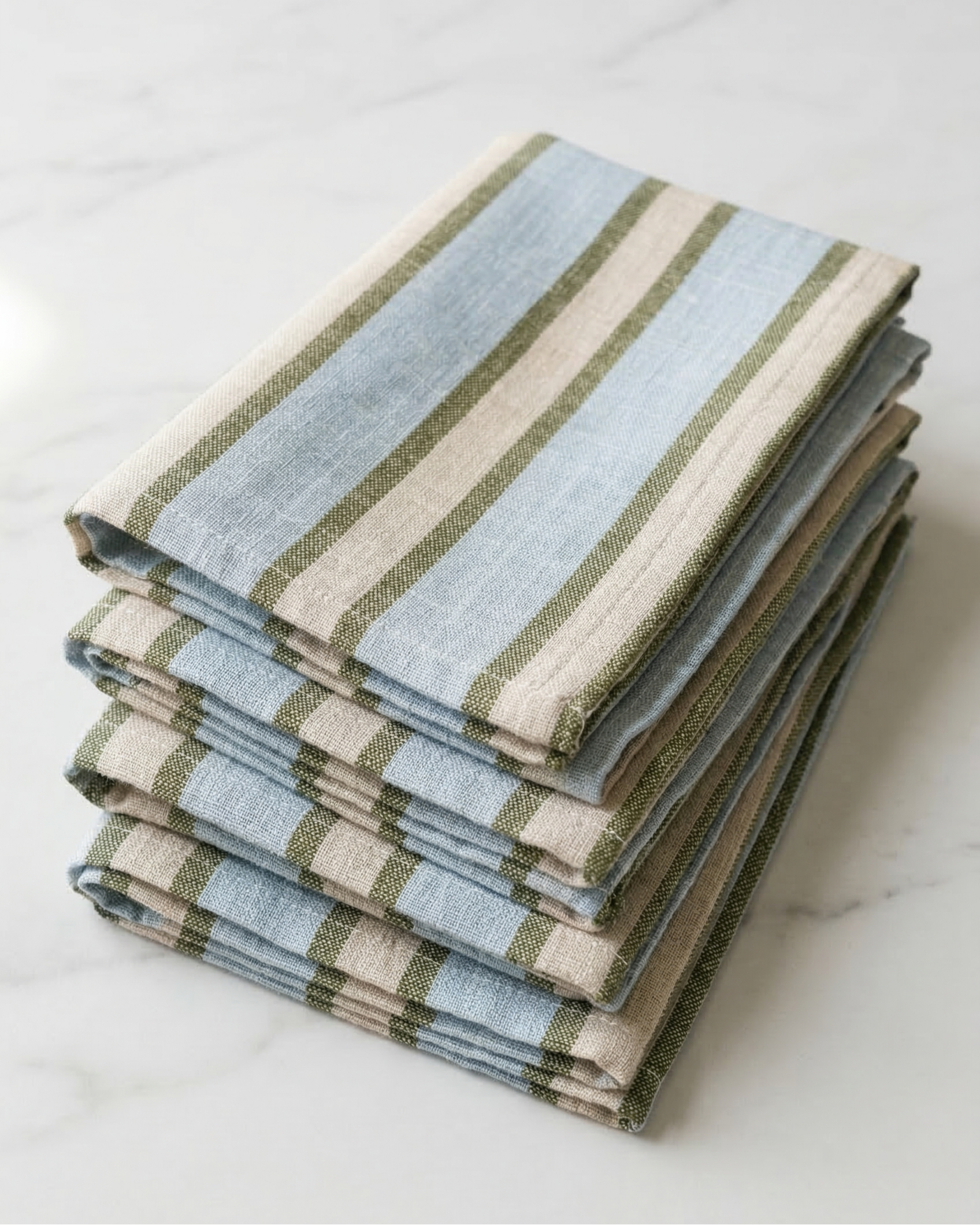 Stack of folded striped towels on a white surface