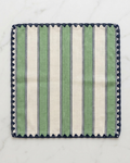 Striped green and white napkin with blue trim on a marble surface