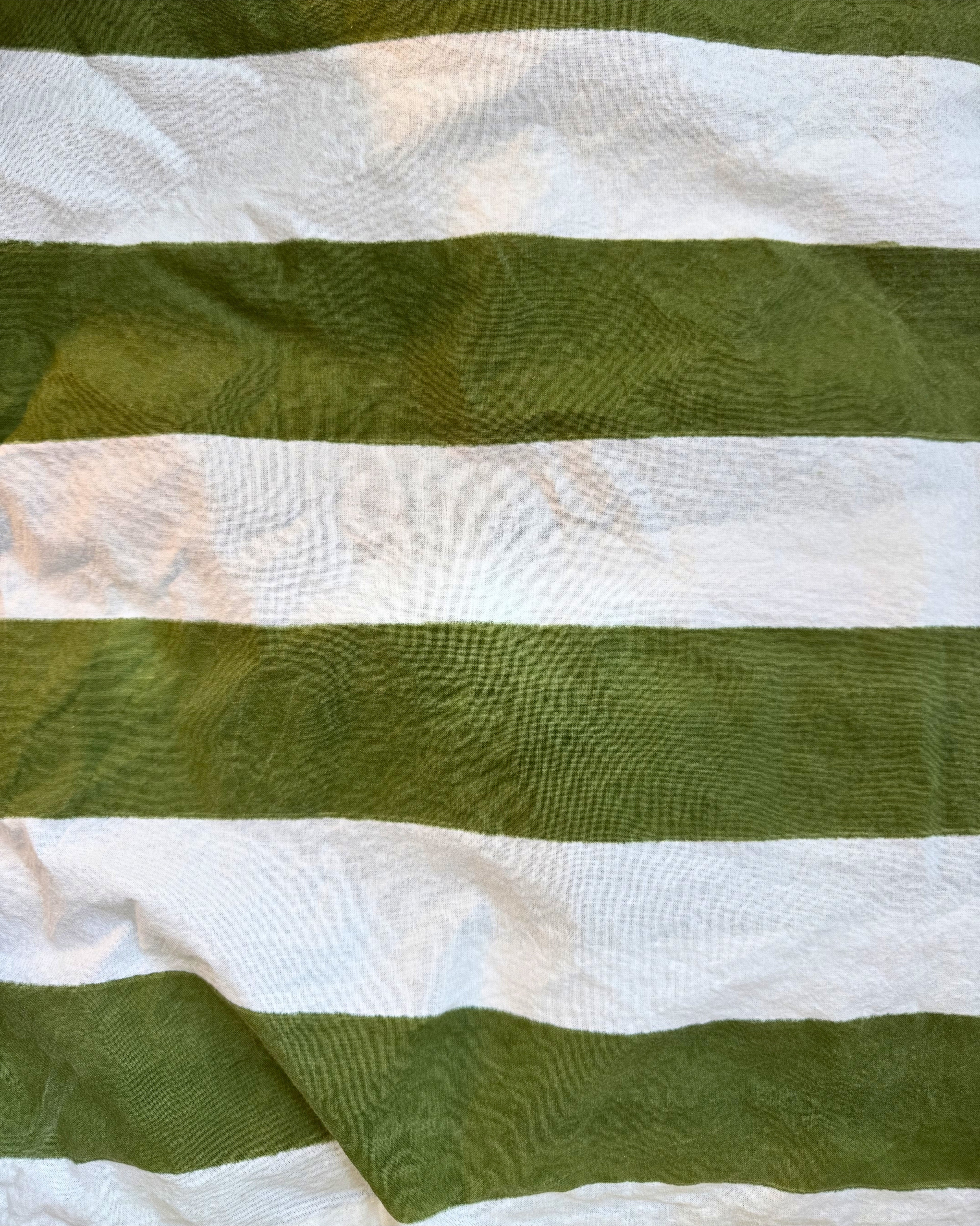 A close-up of a striped fabric with alternating horizontal bands of olive green and white, showing a slightly textured, crinkled material.